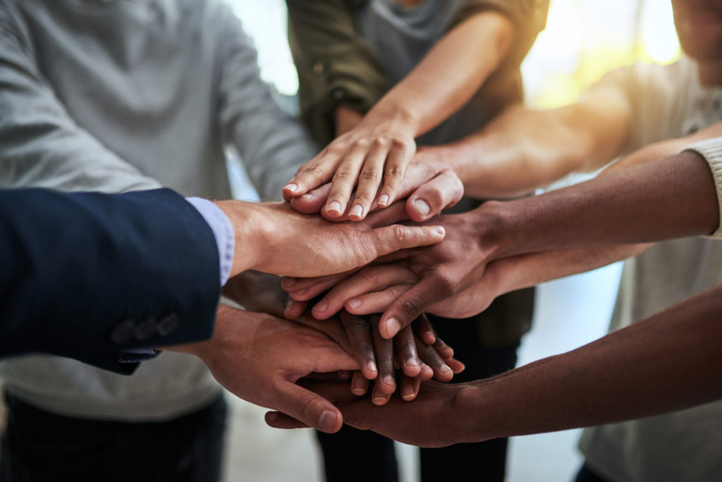 Cropped shot of a group of businesspeople joining their hands in solidarity